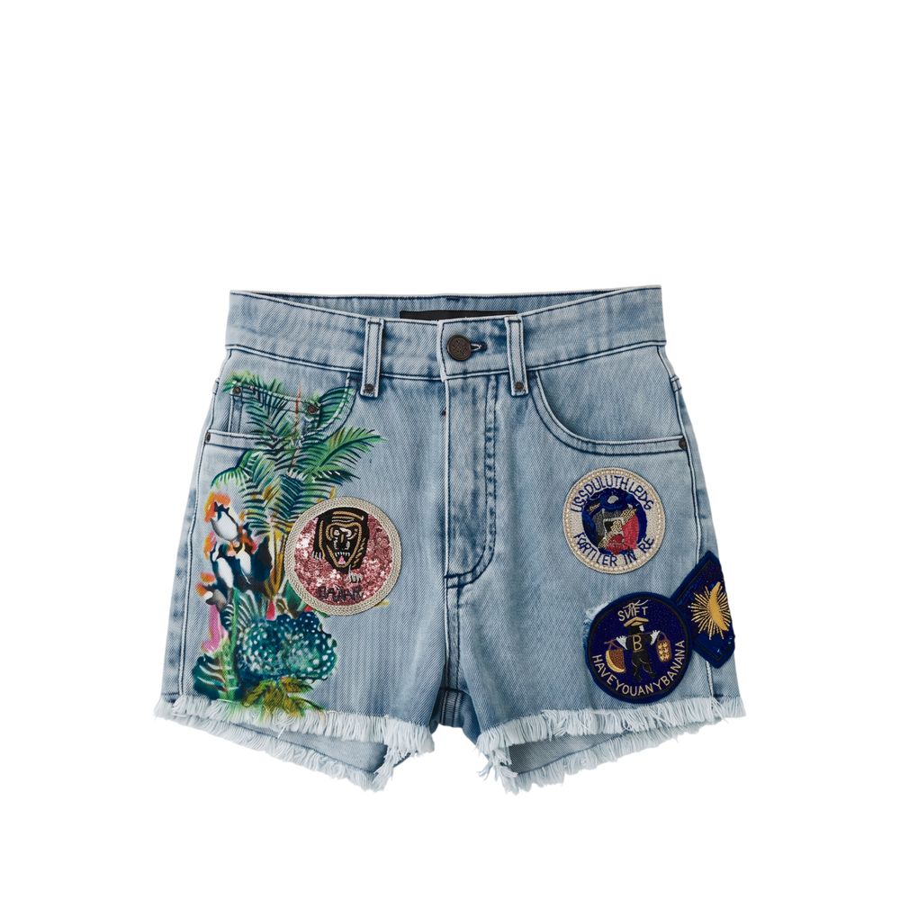 Light wash blue denim shorts with frayed hems, featuring colorful embroidered tropical parrot and palm tree designs on one leg and several circular embroidered patches on the front and side pockets.